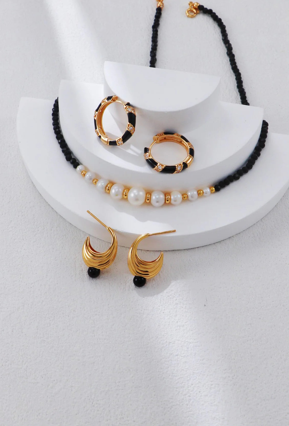 Collar con cuentas doradas y perla de espinela negra.