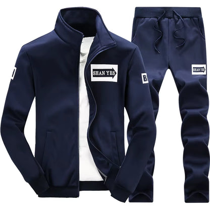 Conjunto deportivo de otoño para hombre. Sudadera y pantalón a juego, con diseño patchwork, cuello alto y capucha.