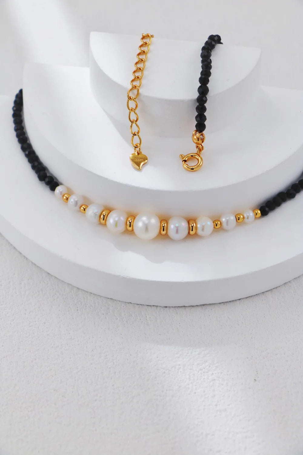 Collar con cuentas doradas y perla de espinela negra.