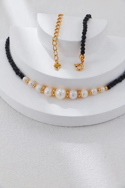 Collar con cuentas doradas y perla de espinela negra.