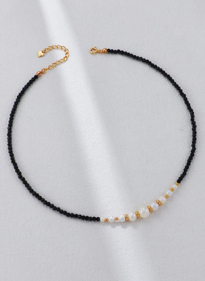 Collar con cuentas doradas y perla de espinela negra.