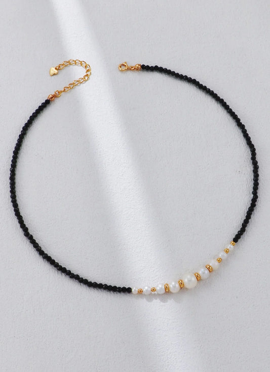 Collar con cuentas doradas y perla de espinela negra.
