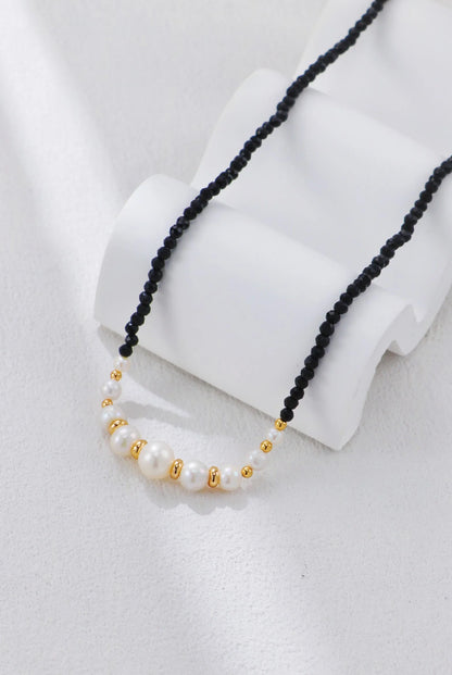 Collar con cuentas doradas y perla de espinela negra.