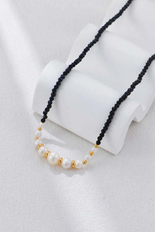 Collar con cuentas doradas y perla de espinela negra.
